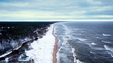 coastline in windy winter with waves and snow