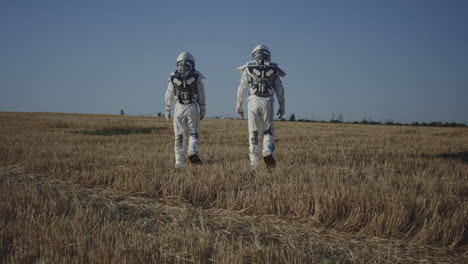 two astronauts exploring a wheat field