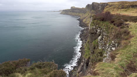 Toma-Estática-De-Olas-Salpicando-En-Los-Acantilados-En-Un-Día-Nublado-En-Escocia,-Isla-De-Skye