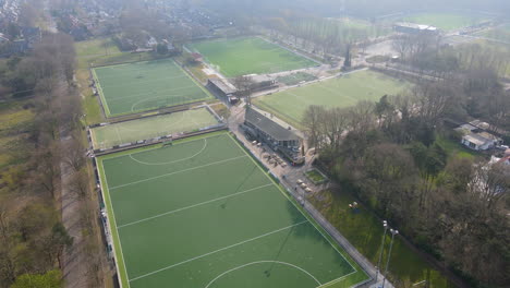 Antena-De-Campos-Verdes-De-Fútbol-Y-Hockey-En-El-Borde-De-Un-Pequeño-Pueblo