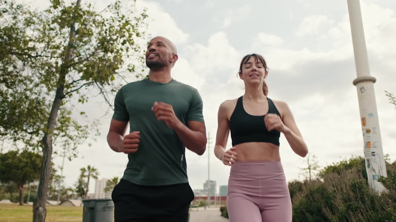 Coppia in forma che corre insieme in un parco