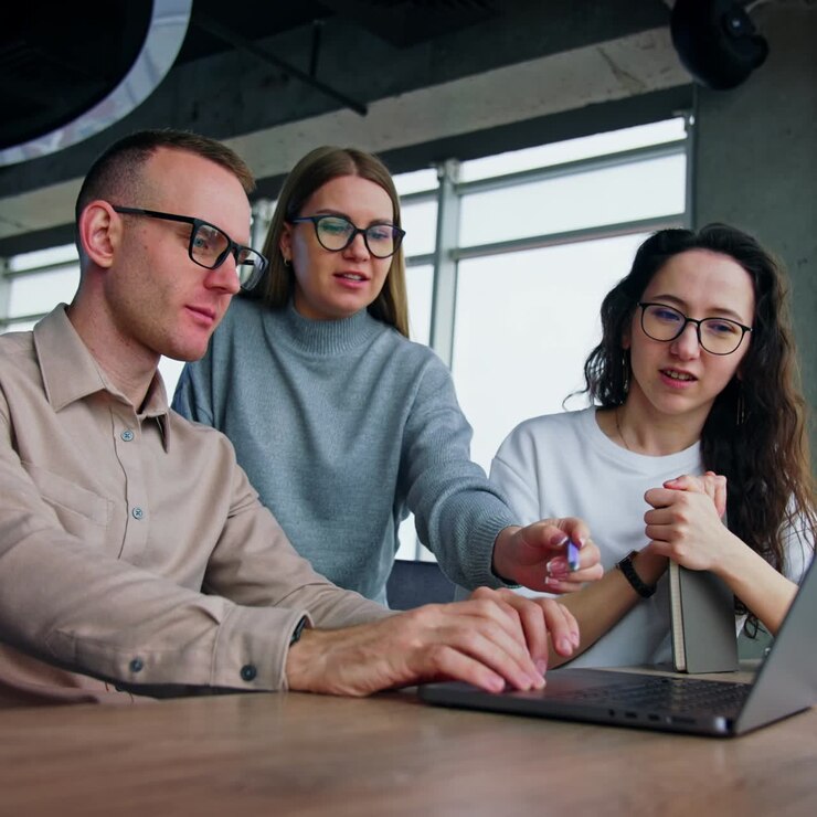 Business communication among the colleagues in office. Co-workers smile discussing the images on the screen