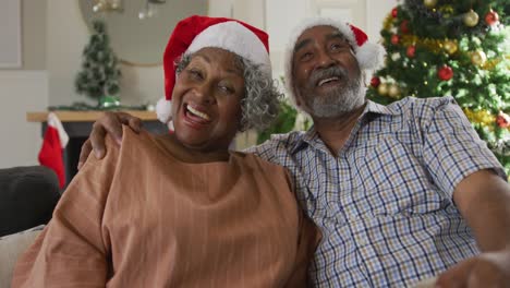 Animation-of-happy-african-american-senior-couple-having-video-call-at-christmas-time