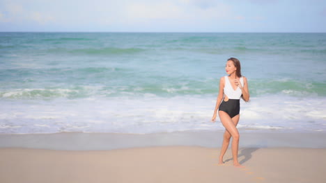 Sexy-Asiatische-Frau,-Die-Am-Sandstrand-Der-Tropischen-Insel-Aus-Dem-Meer-Geht,-Zeitlupe