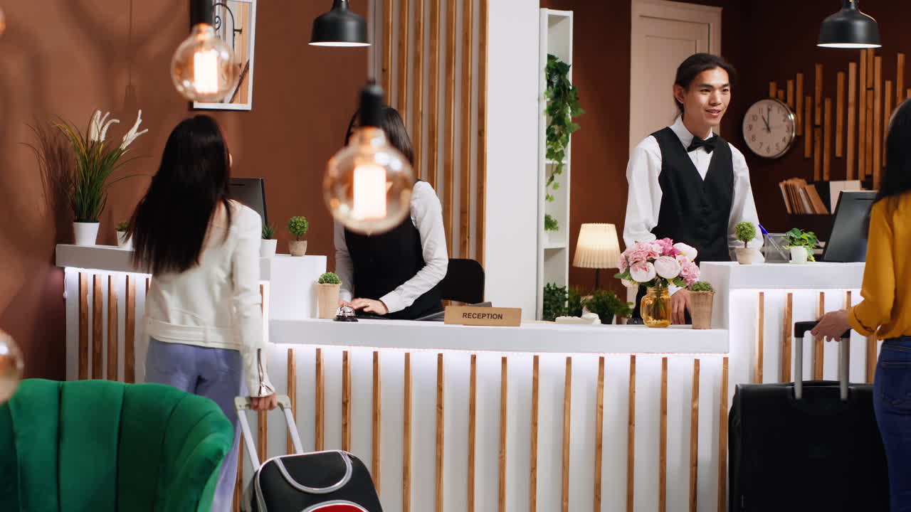 젊은 고객이 호텔 로비의 프런트 데스크에 다가오고 있습니다.