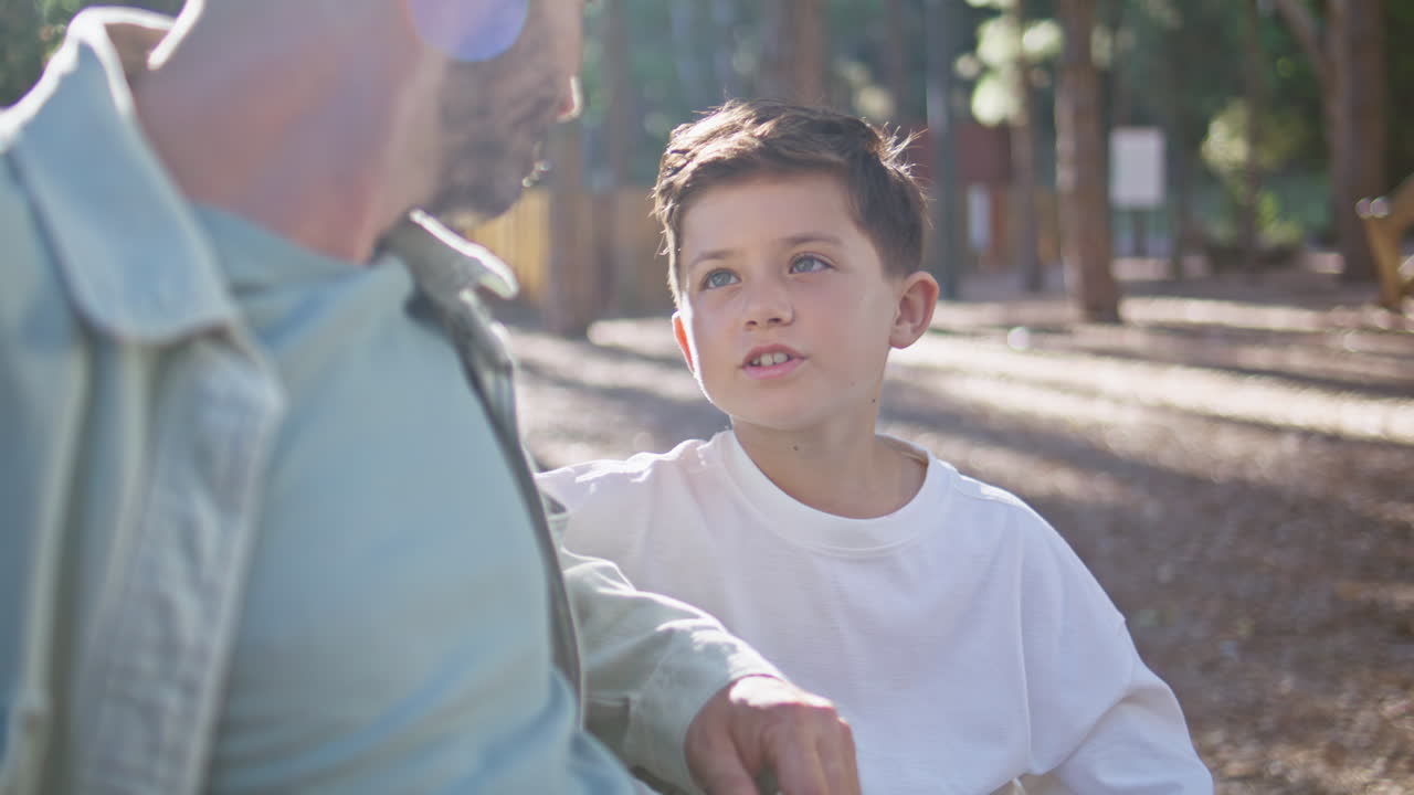 Father boy enjoy conversation on sunny bench closeup. Relaxed family talking