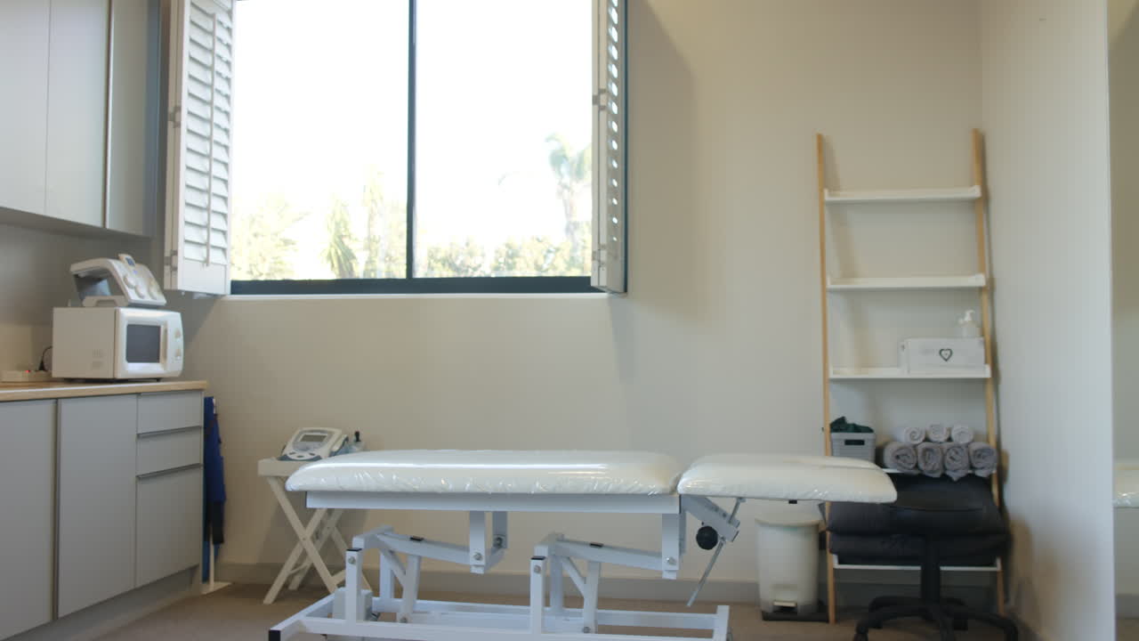 Medical examination room showing empty treatment table and medical equipment