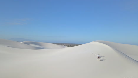 aerial of man hiking on sand dunes in south africa