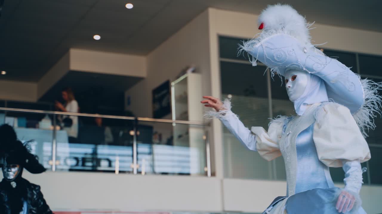 Beautiful masquerade show indoors. Woman and man in masks and carnival costumes in the show programme.
