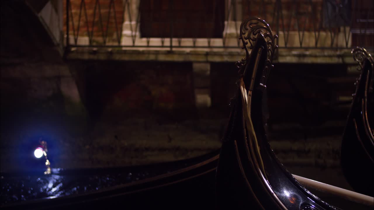 Gondole ormeggiate in un canale buio di Venezia di notte