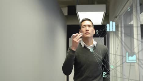 animation of globe of digital icons spinning against asian man talking on smartphone at office