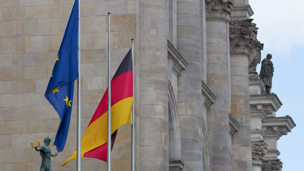 Bandiere tedesche ed europee sventolano accanto a colonne di pietra, cielo nuvoloso, telecamera statica, architettura di Berlino