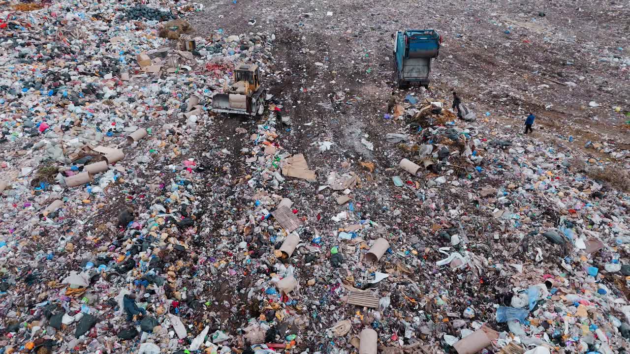 Aerial View of Landfill with Garbage Trucks and Excavator