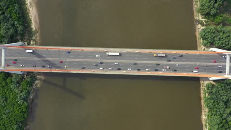 coche de la ciudad moviéndose en el puente de la autopista en la superficie del río suave de fondo vista de drones