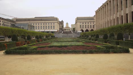 garden with square shaped bushes next to a statue in brussels