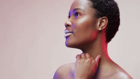 african american woman with short dark hair in blue and pink light with copy space, slow motion
