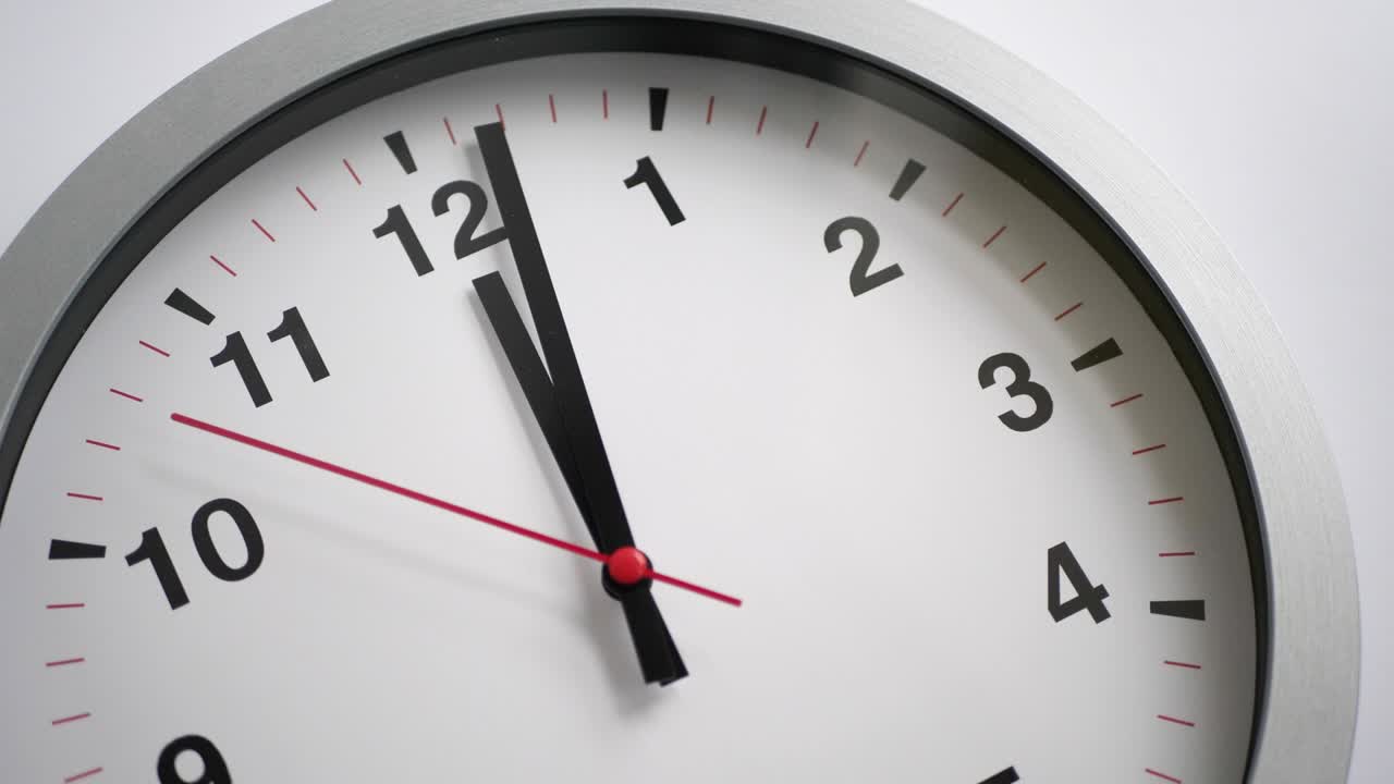 Orologio che ticchetta su sfondo bianco, time lapse.