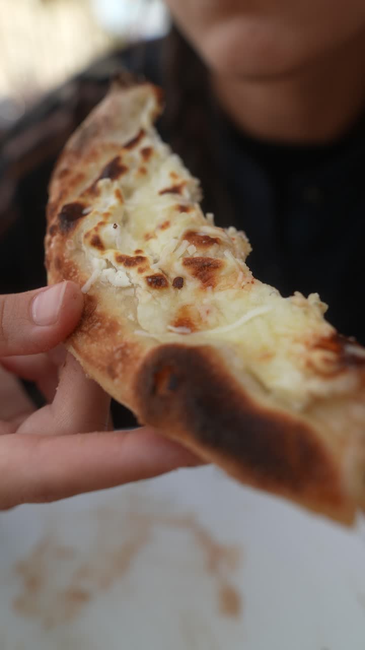 Persona che mangia una fetta di pane al formaggio