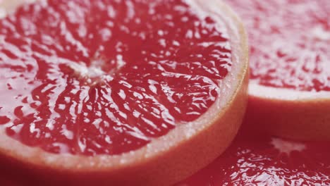 micro video of close up of red grapefruit slices with copy space