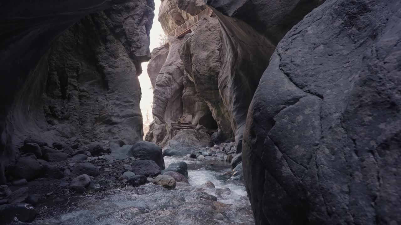 A scenic canyon with a flowing river and a bridge