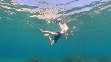 Blick-Auf-Einen-Jungen-Taucher,-Der-An-Der-Oberfläche-Im-Mittelmeer-Schwimmt