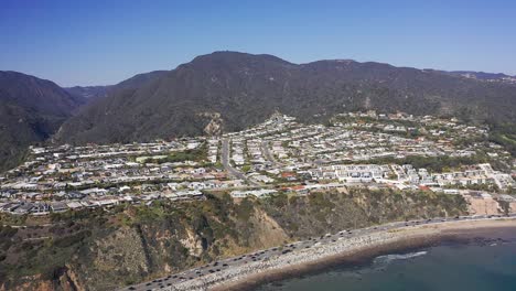 Super-wide-aerial-shot-from-the-Pacific-Ocean-flying-towards-Malibu-Bluffs-in-California