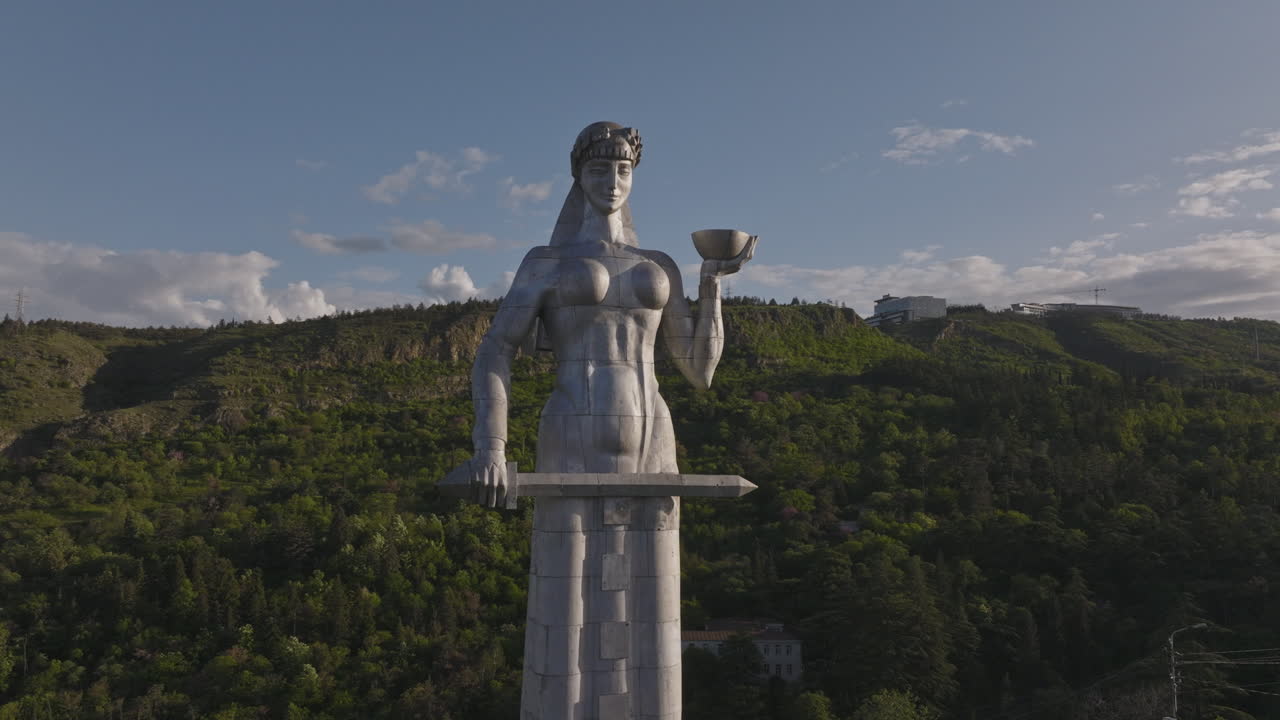Aerial shot of giant cemented status featuring greenery in the backside