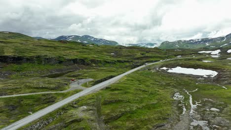 Aerial-view-of-white-bus-and-cars-driving-over-Vikafjellet-mountain-pass-in-western-Norway