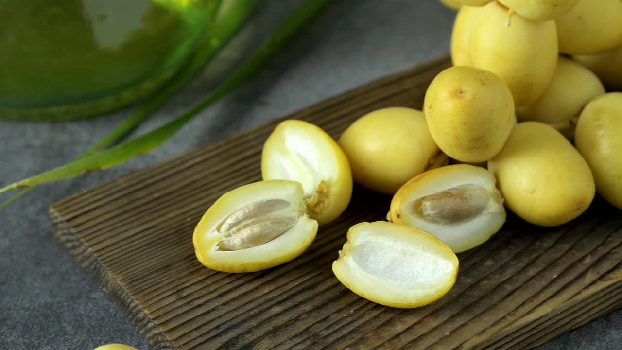 las palmeras de dátiles frescas se colocan en la mesa con aceite, concepto de alimentos saludables. palmeras de dátils. frutas crudas de palmieras de dátiles (phoenix dactylifera)