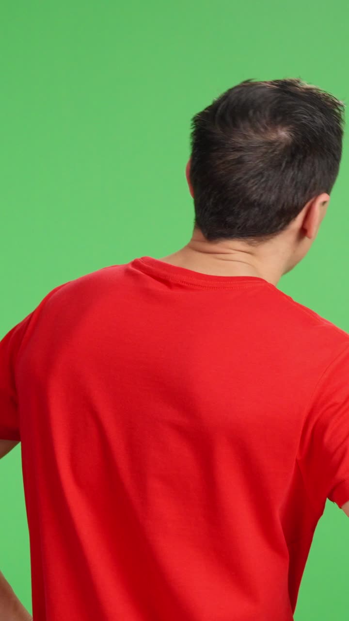 Smiling man pointing and gesturing on green screen background
