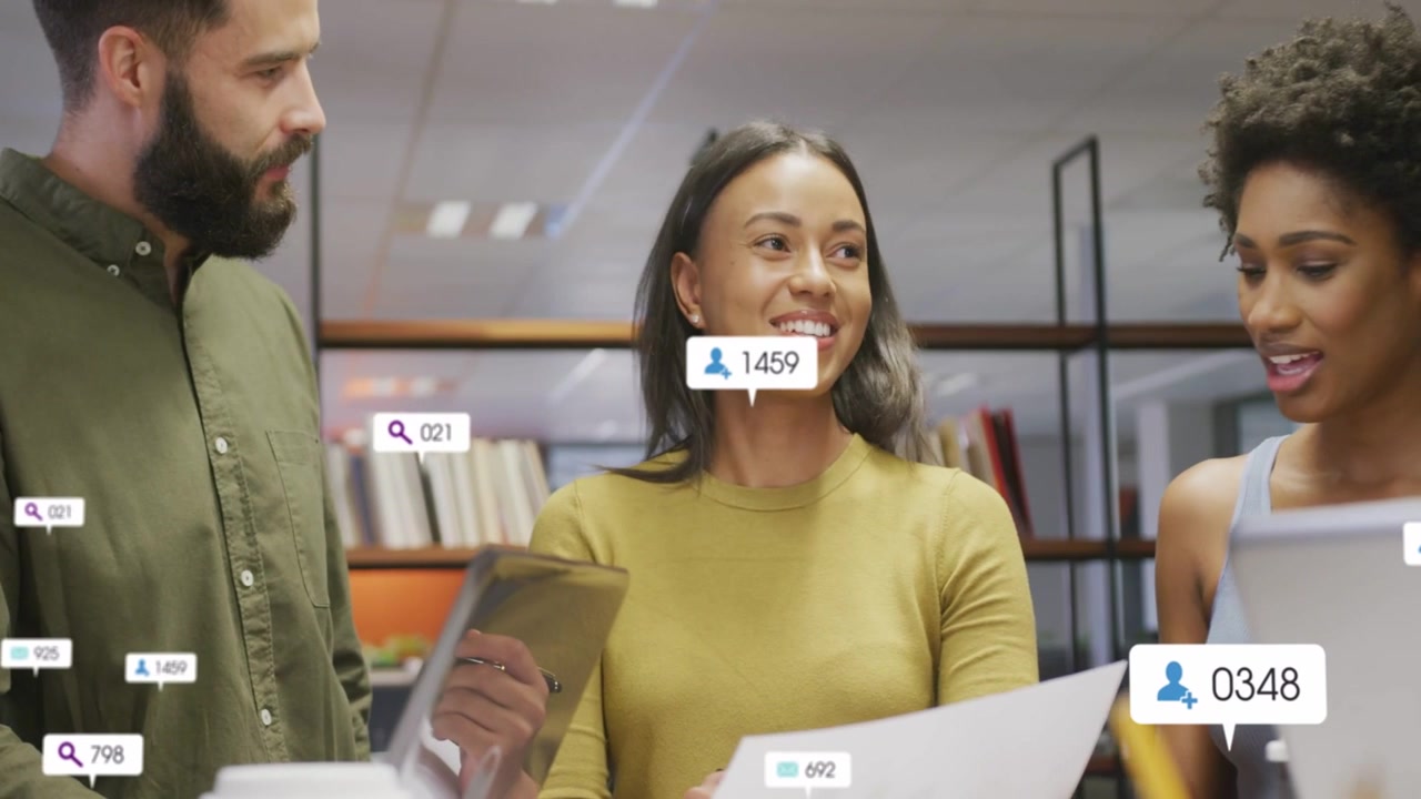 Center woman showing tablet and speaking, causing data bubbles over docs for business review