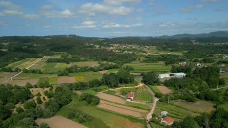 green fields and town in a maquieira, barro, spain - aerial drone shot