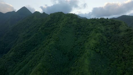 teahupoo tahiti high altitude mountain peaks hills valley sunrise aerial drone view french polynesia yellow clouds golden hour sunset wsl surfing summer olympic venue town village coast forward up