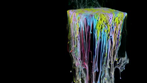 multicolored ink paint slowly flows from the cube underwater