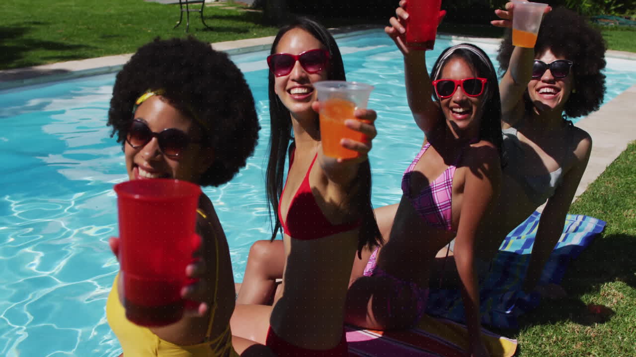 Women in swimsuits by pool holding drinks with digital target animation overlay