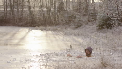 zoom in - a cyclist rides past as the ice bather sits in freezing cold water