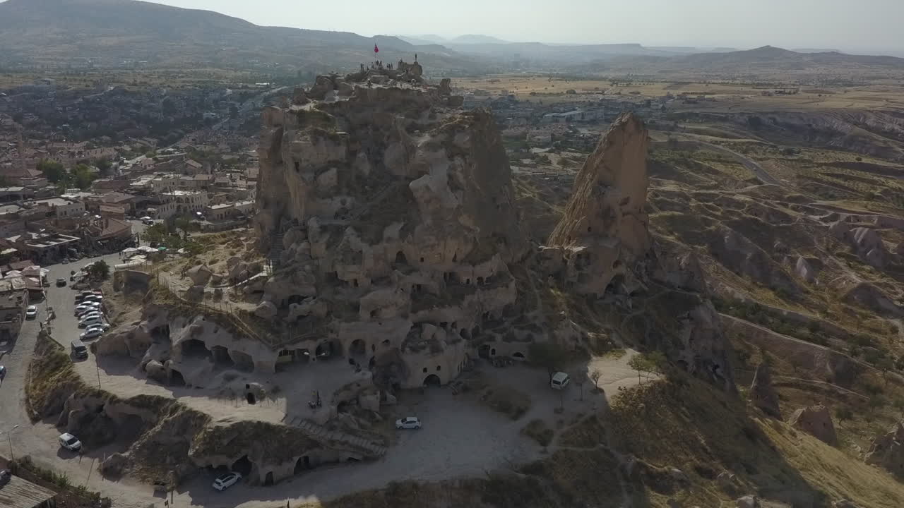 Orbiting aerial of Uchisar Castle, natural cave tower in Cappadocia