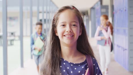 Porträt-Eines-Glücklichen-Kaukasischen-Schulmädchens,-Das-Im-Schulkorridor-Spaziert