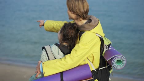 couple exploring nature. hiker pointing finger on seaside view