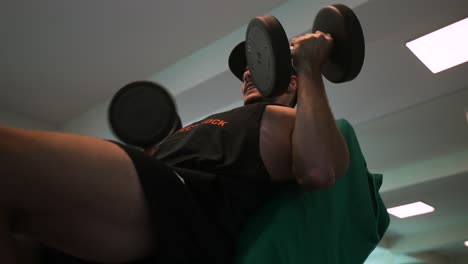man model in the gym working out with weights