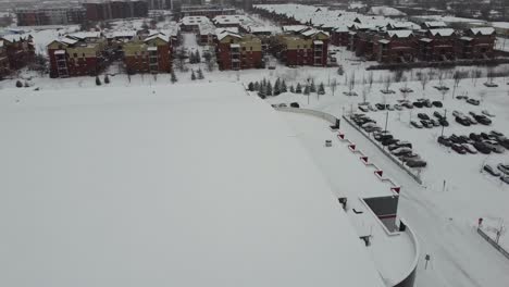 Erleben-Sie-Die-Ruhige-Schönheit-Eines-Verschneiten-Parkplatzes-Im-Winter,-Während-Eine-Drohne-In-Die-Höhe-Fliegt-Und-Atemberaubende-Luftaufnahmen-Einfängt