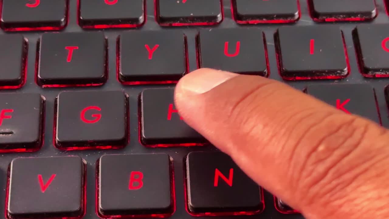 Finger pressing "H" keys on glowing keyboard, symbolizing fast typing, technology, and productivity