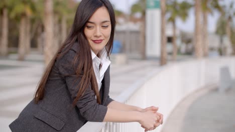 Relaxed-thoughtful-young-woman-leaning-on-railings