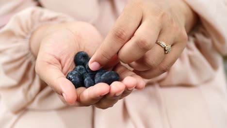 Women-eating-berry-fruit-close-up-,