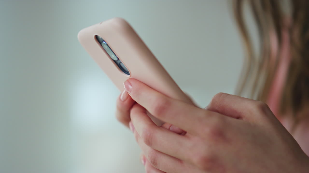 manos de primer plano deslizando el teléfono inteligente en una habitación oscura. niña desconocida revisa las redes sociales
