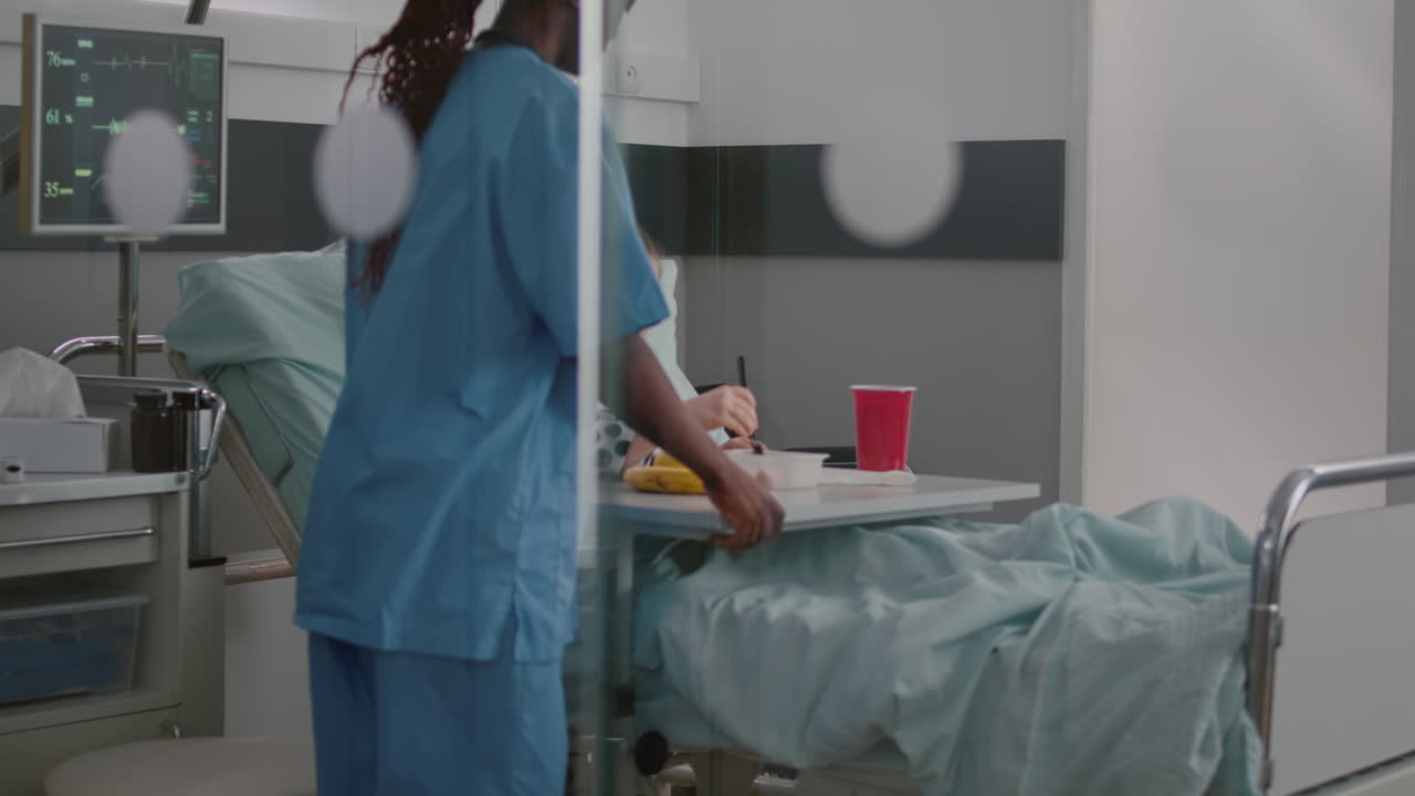 African american nurse bringing healthy nutrition food meal to sick patient