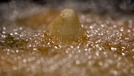 SLOWMO-macro-close-up-of-Brazilian-coxinha-deep-frying-in-oil