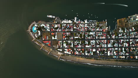 Birds-eye-drone-shot-ascending-above-the-Puntarenas,-sunny-evening-in-Costa-Rica