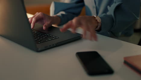 woman working at her desk with laptop and phone