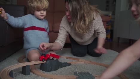 mother with kids playing with toy roadway